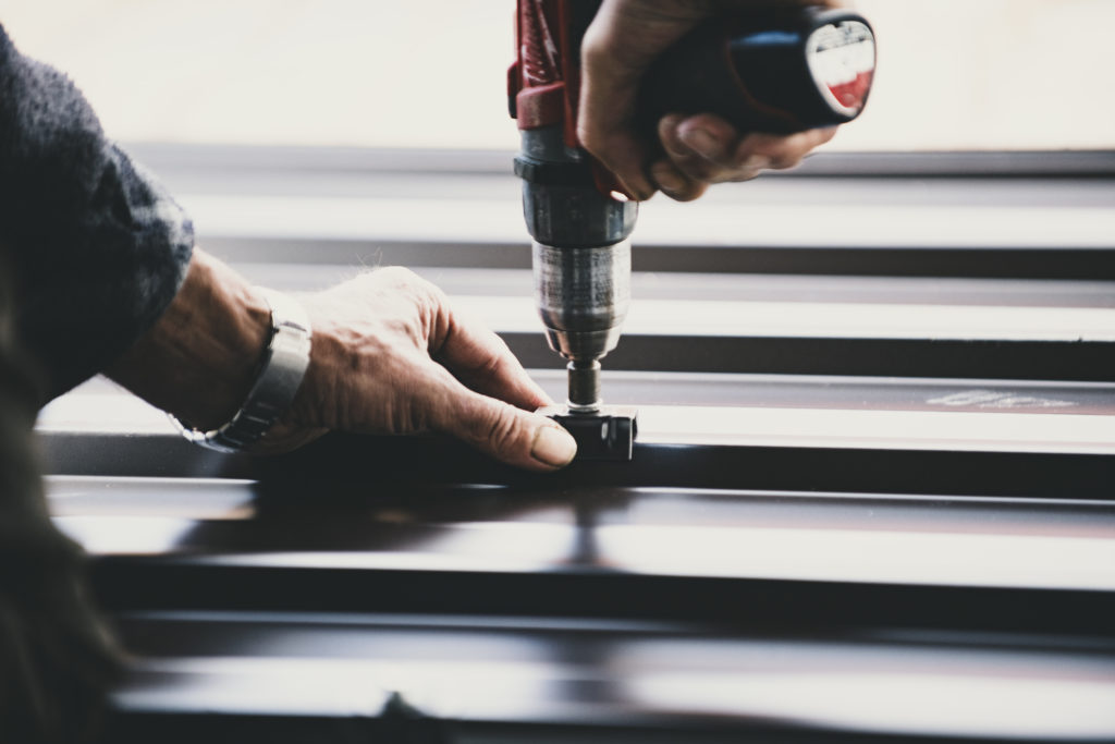 Building contractor is installing metal roofing sheets man installing roof